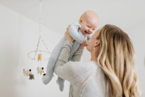 Mother throwing baby boy in air in bedroom Mother throwing baby boy in air in bedroom